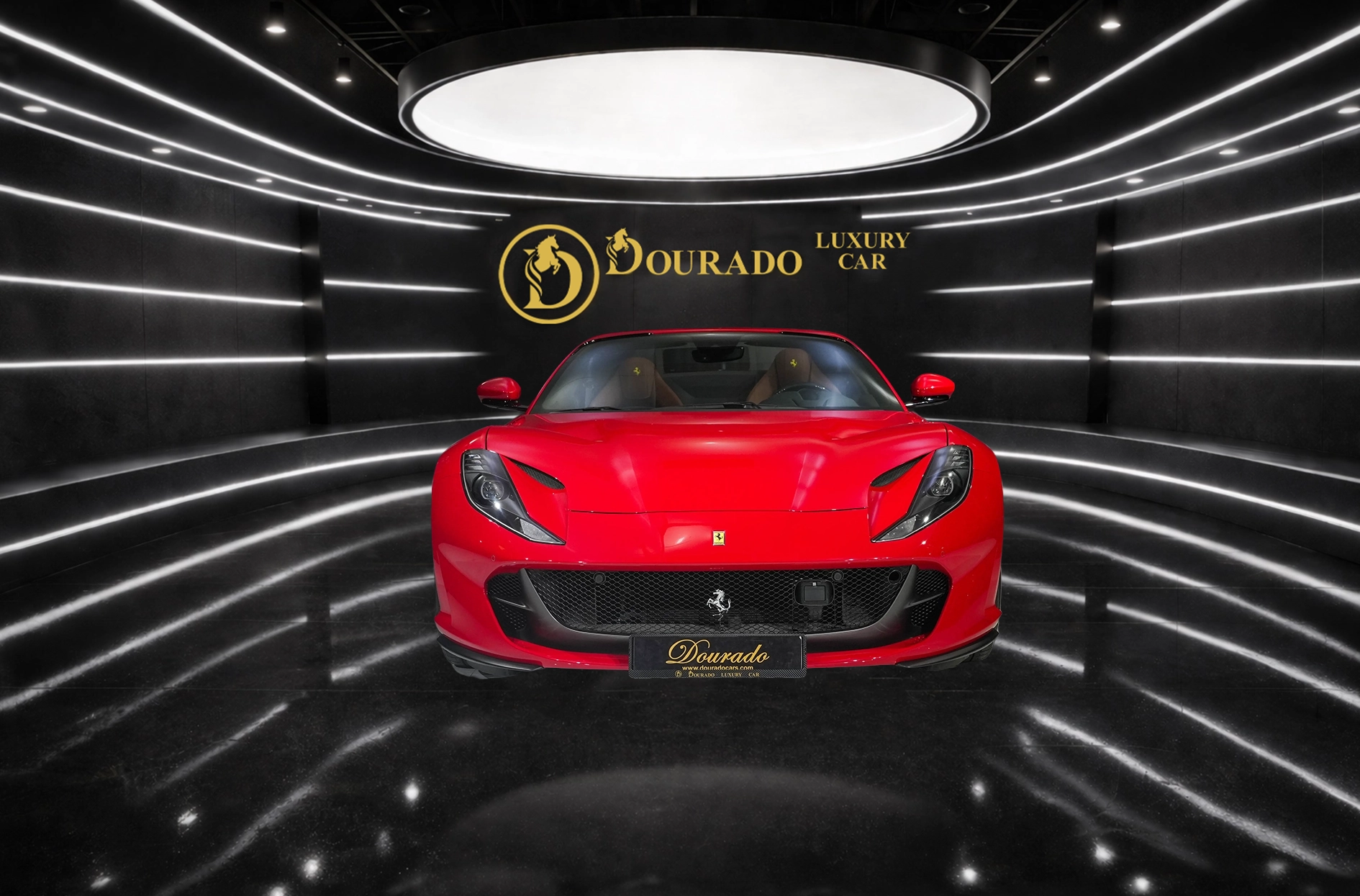 Red Ferrari sports car centered in a sleek luxury showroom with black curved walls and white light strips, and a gold Dourado logo on the back wall.