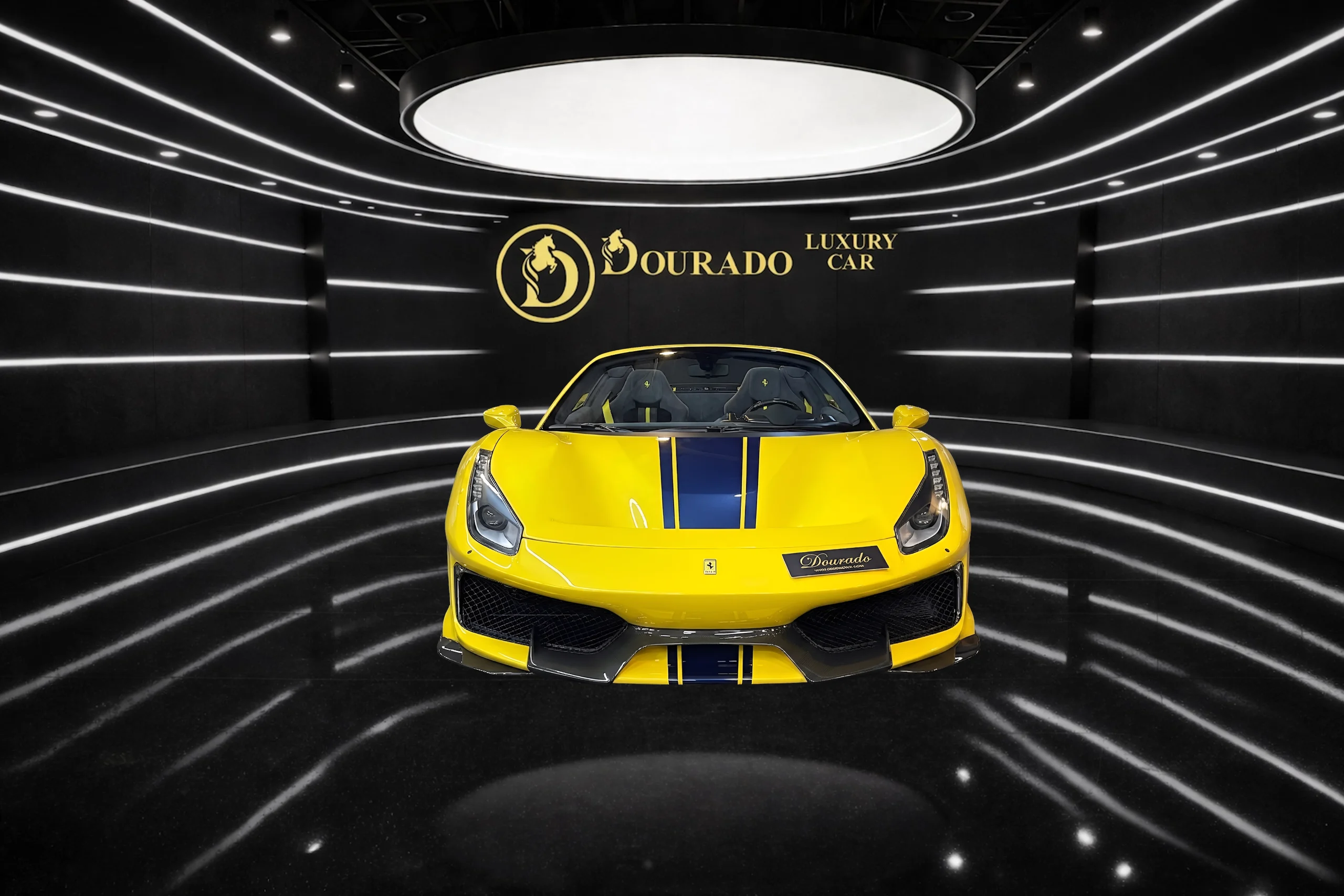 Front view of a bright yellow sports car with a blue racing stripe, parked in a sleek black showroom with curved white light strips on the walls and ceiling."The car is centered under a large circular light."